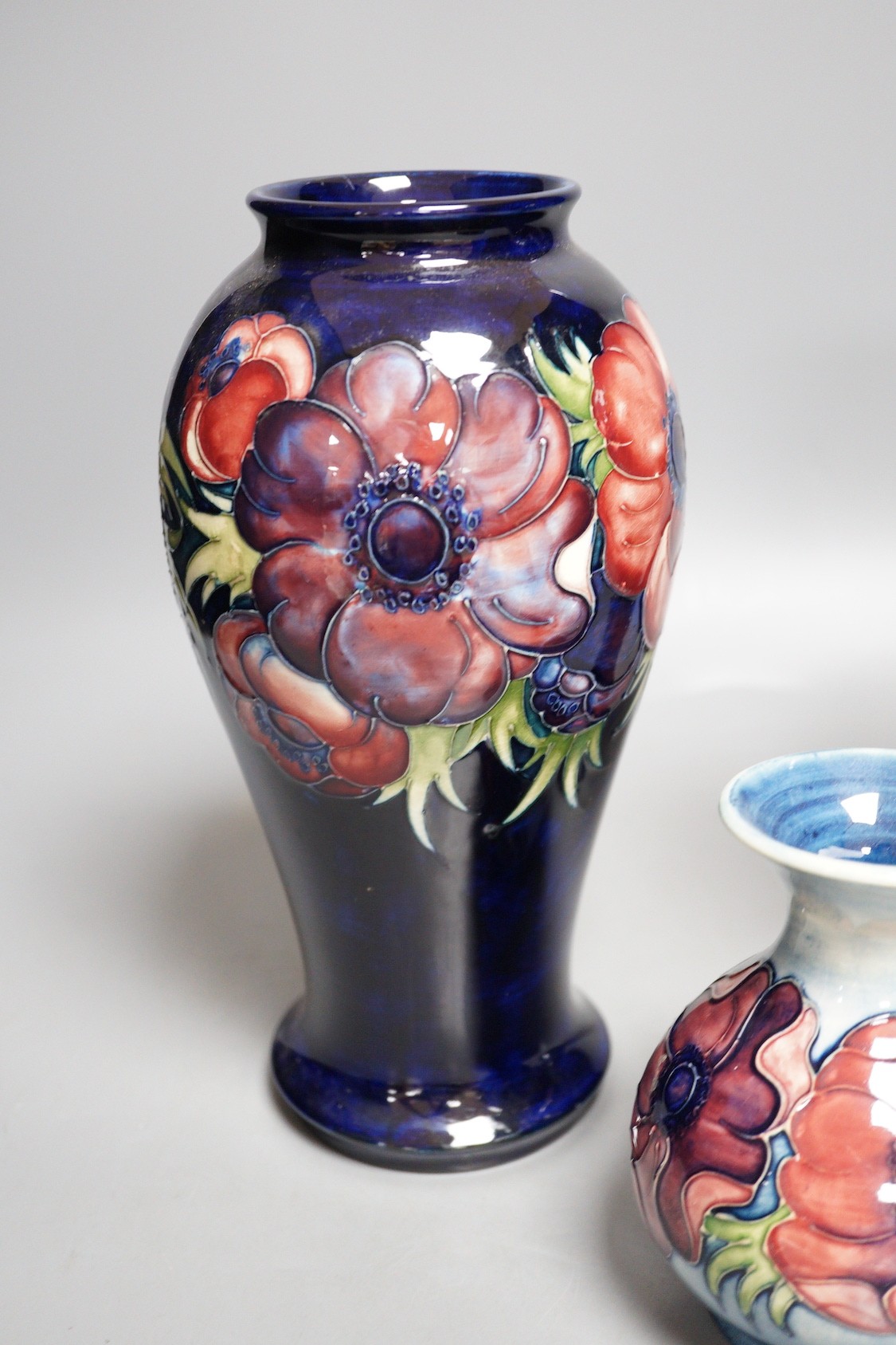 Three William Moorcroft anemone pattern vases, tallest 27cm